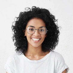woman with glasses smiling with curly hair